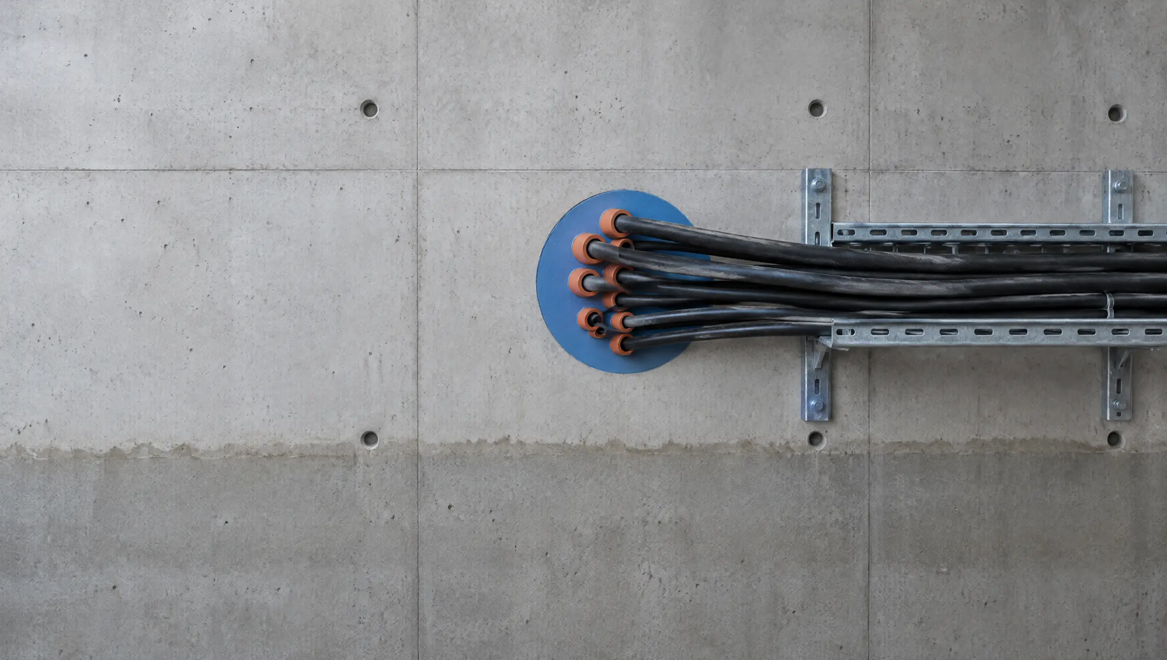 Abgedichtete Kabeldurchführung in einer Betonwand, Kabel auf einer Kabeltrasse